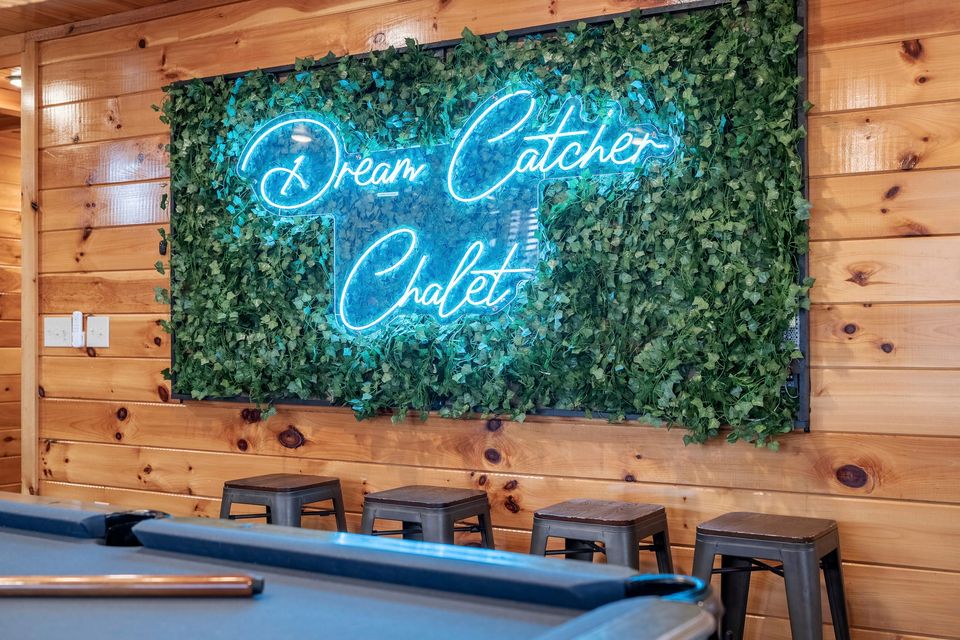 Neon Dream Catcher Chalet sign on a living wall above the pool table
